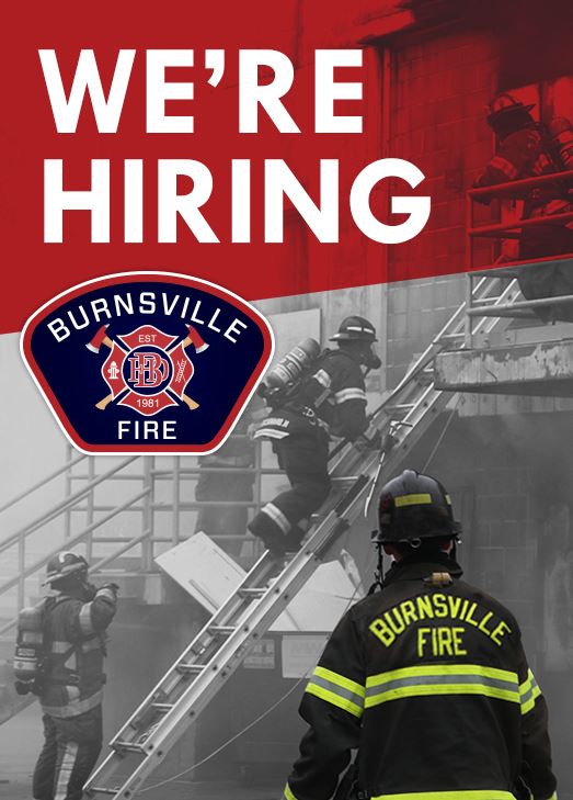 Smokey training facility with firemen climbing up a ladder and one onlooking Text: We're Hiring
