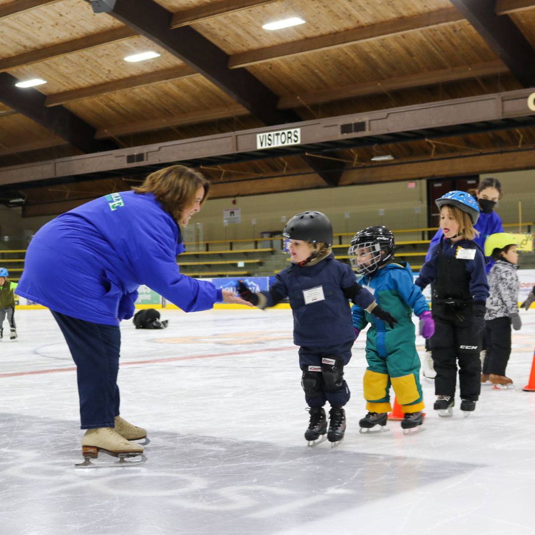An Ice Center instructor leading a group of young skaters