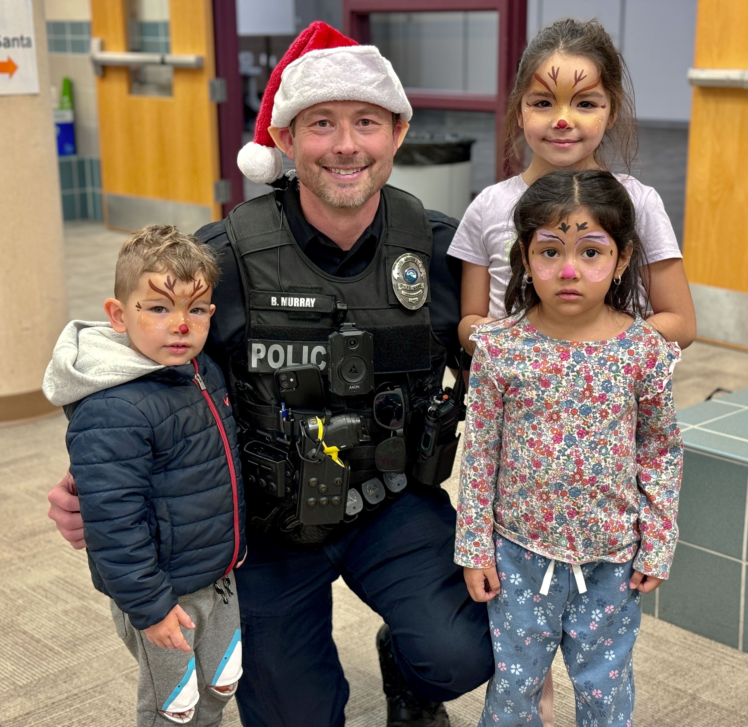 Police officer with kids with holiday face paint