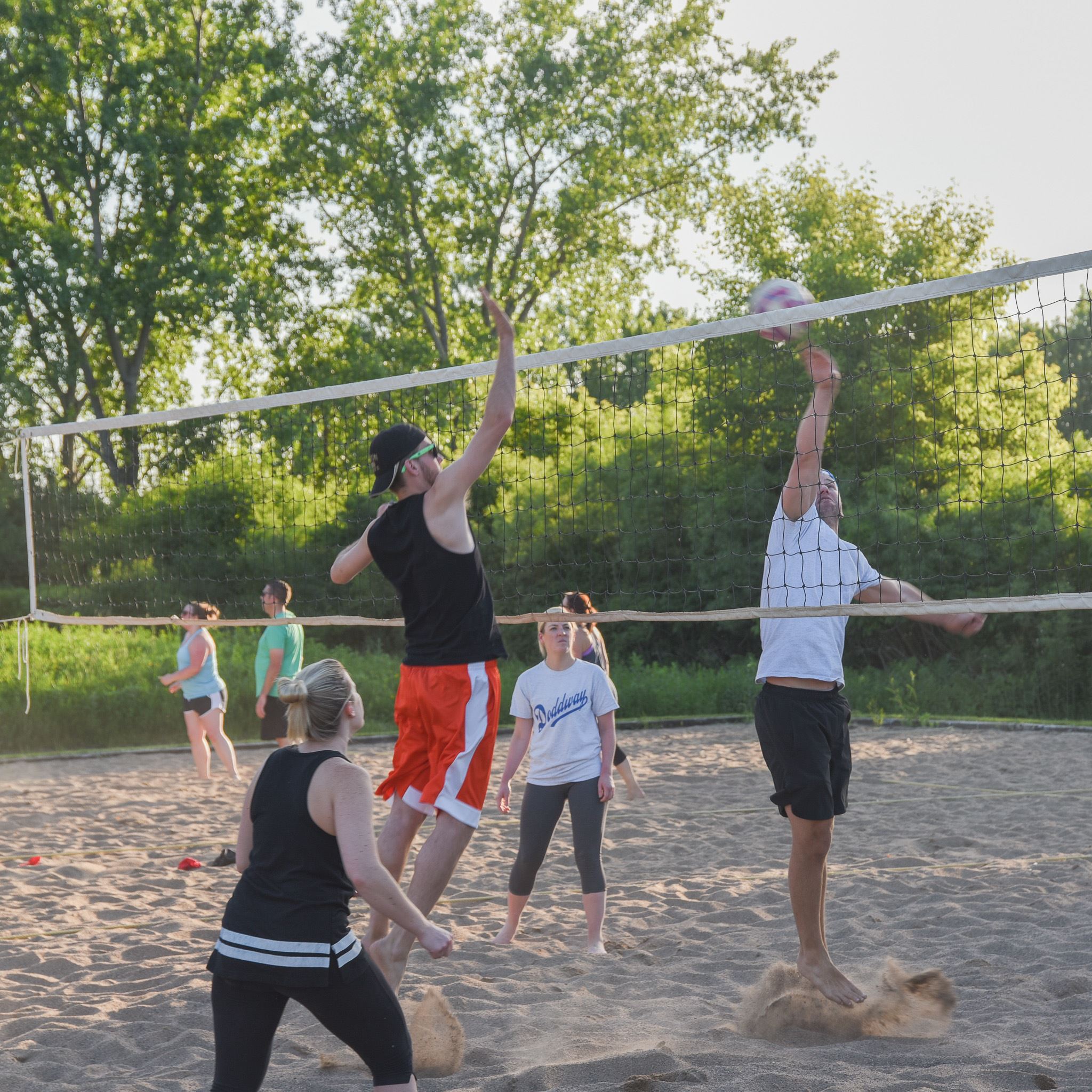 Sand volleyball payer hitting ball over the net